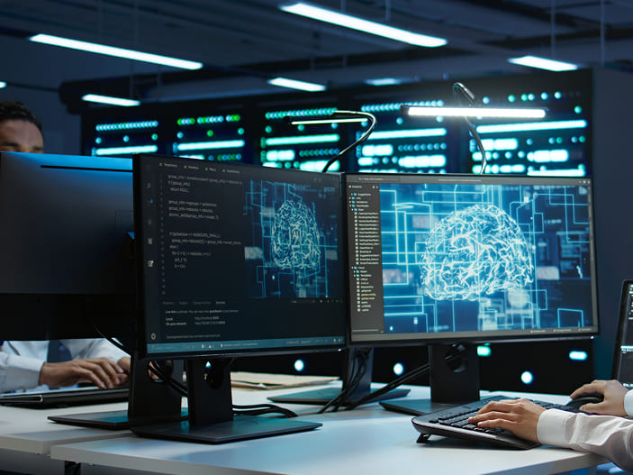 Imagen de personas trabajando con IA en computadoras
